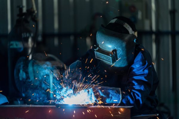 A,Workers,Wearing,Industrial,Uniforms,And,Welded,Iron,Mask,At