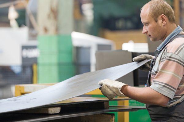 Factory,Man,Worker,Holding,Metal,Sheet,In,Workshop,During,Manufacturing